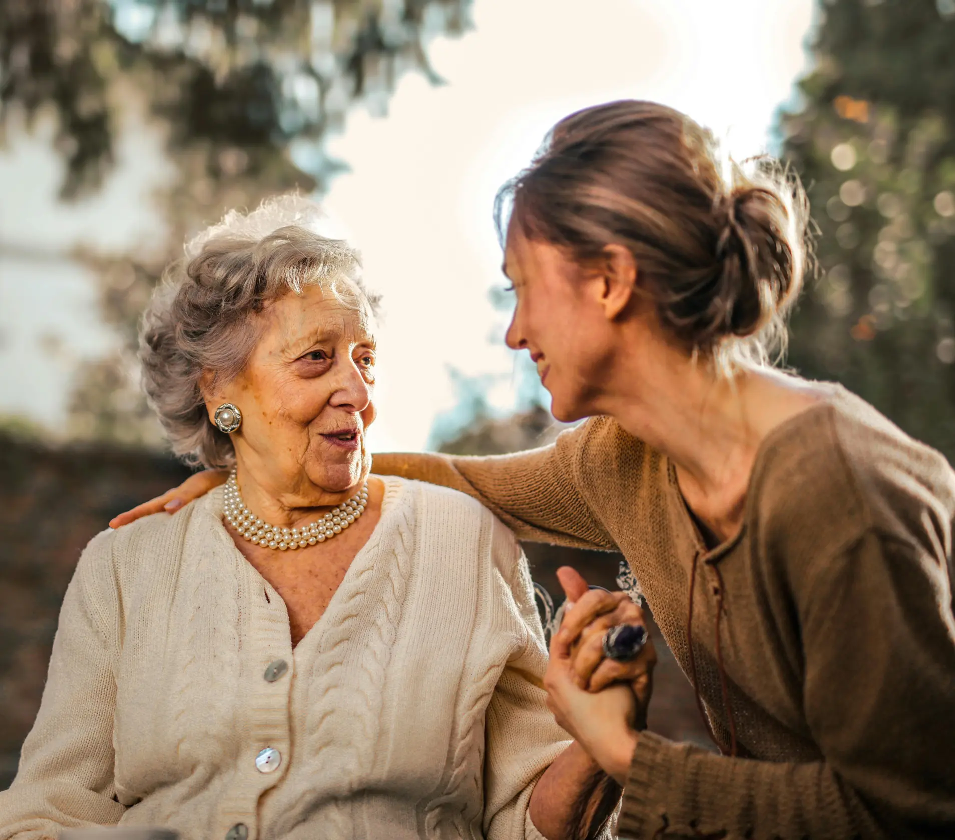 Elderly woman enjoying time with caregiver outdoors.