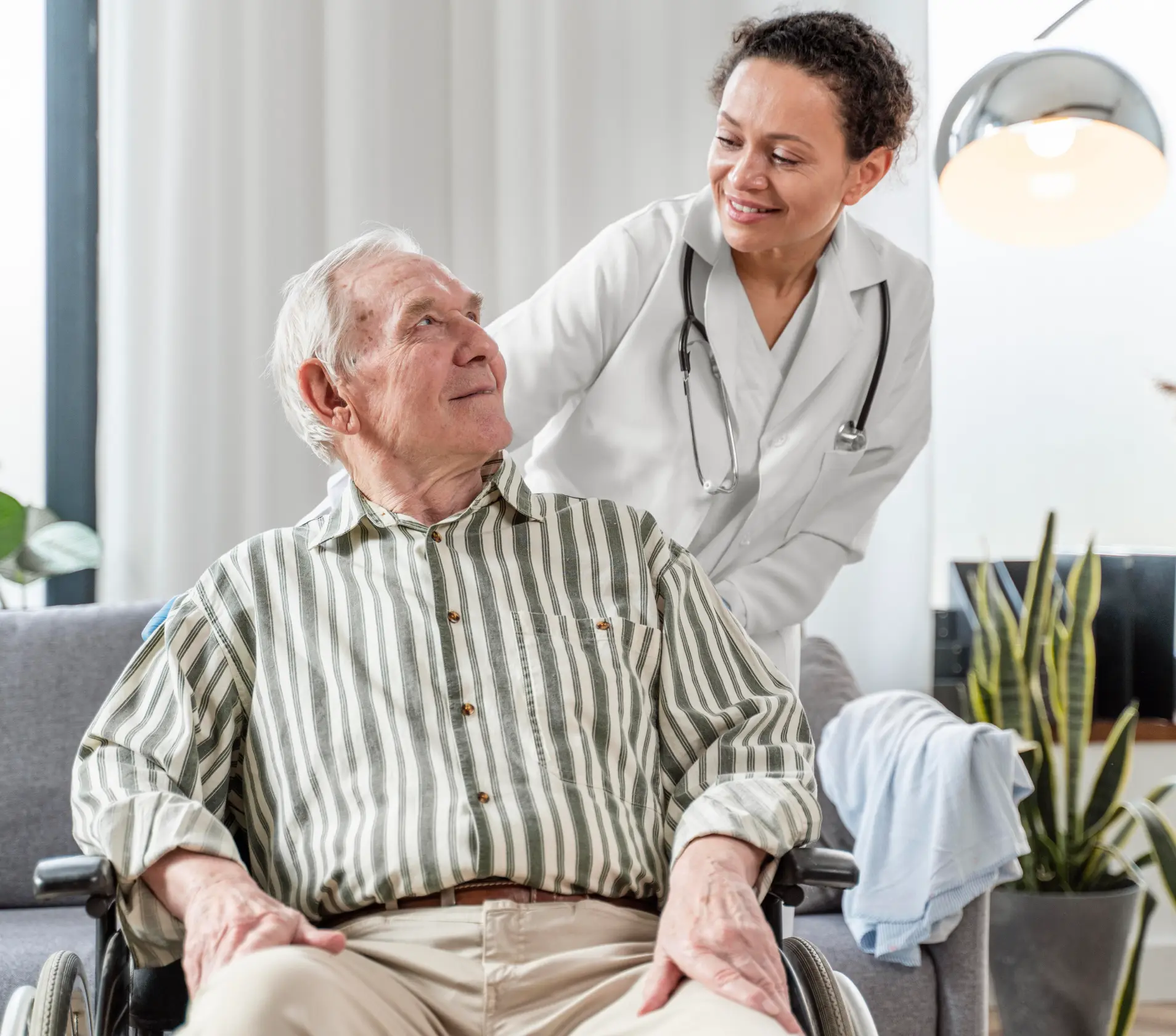 Caregiver assisting an elderly man in a wheelchair.