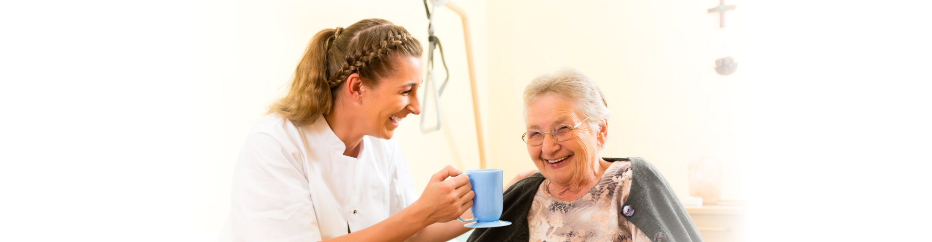 Caregiver serving tea to smiling resident