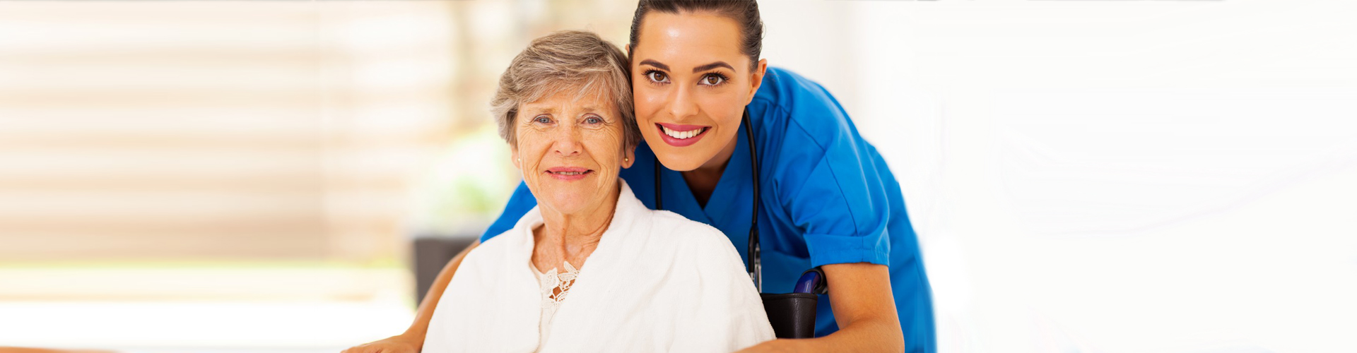 Caregiver and elderly woman smiling together