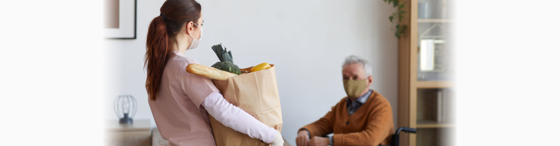 Staff member delivering groceries to a resident.