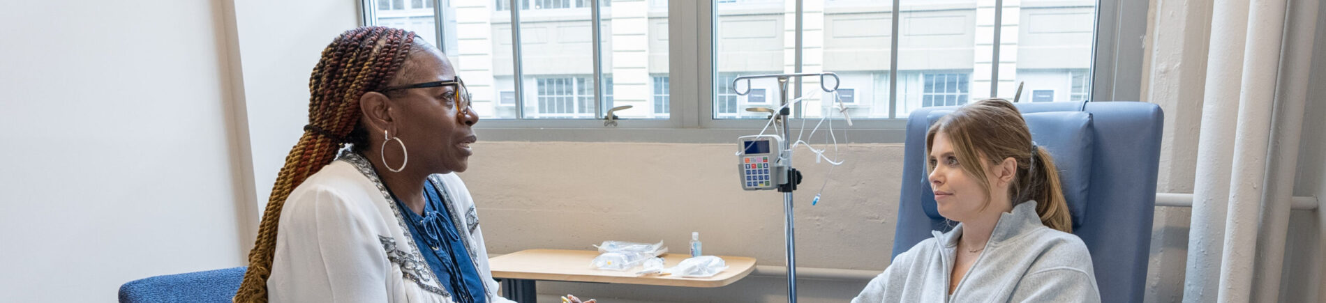 Two women engaged in a conversation during treatment.