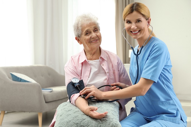 Healthcare professional assisting an elderly woman