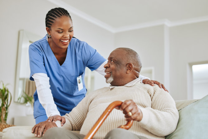 Nurse interacting with elderly resident in a living space.