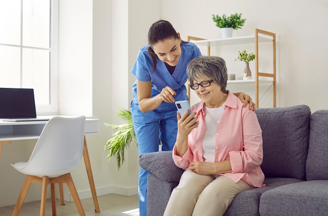 Staff assisting a resident with a smartphone.