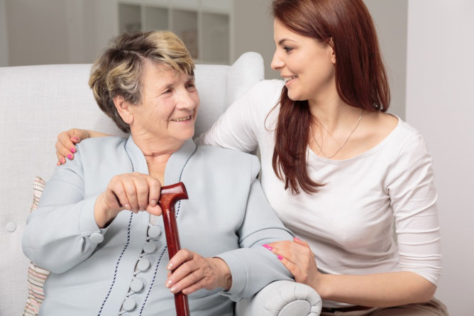 A caregiver smiling with an elderly resident.