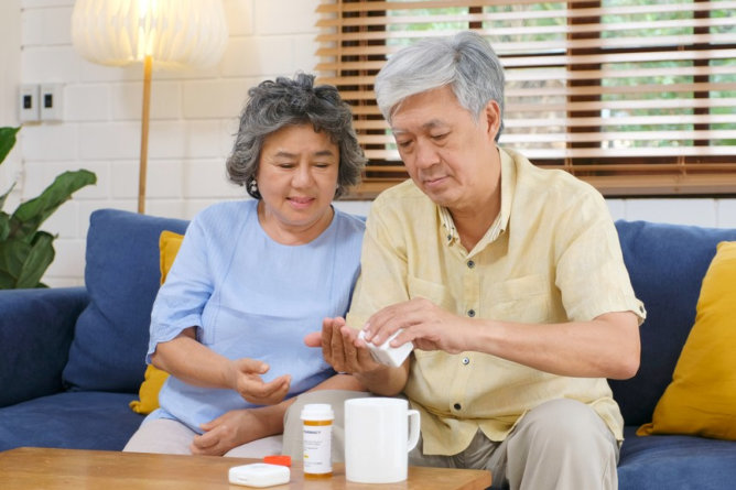 Seniors discussing medication in a cozy living space.