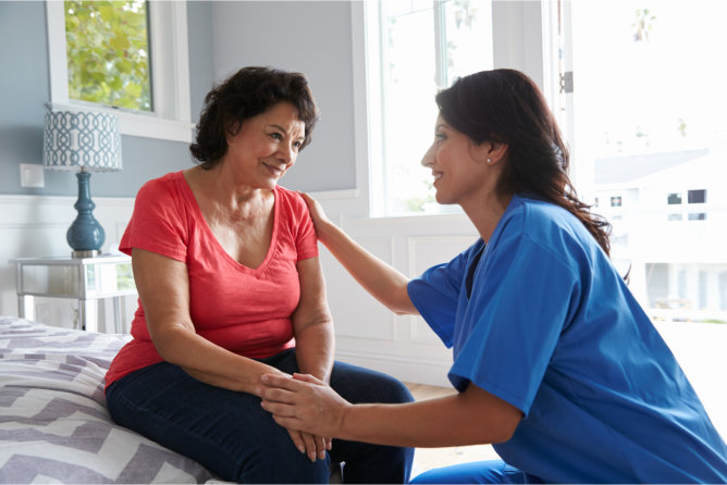 Caregiver interacting with a resident in a cozy room.