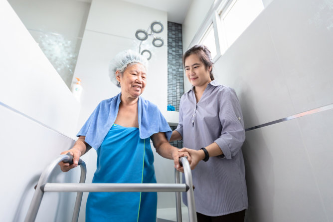 Caregiver assisting senior in a shower setting