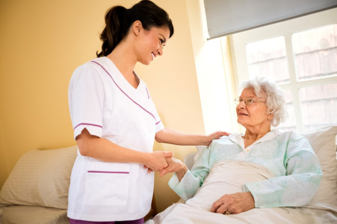 Nurse interacting with a resident in a room.