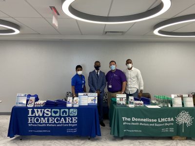 Staff members at a care services event booth.