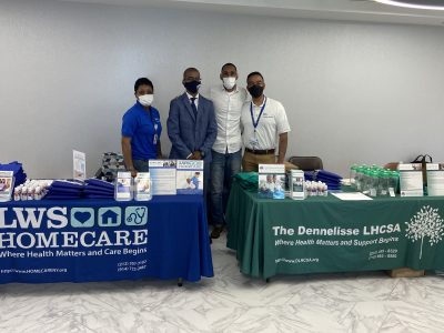 Staff members at a health care event with tables.