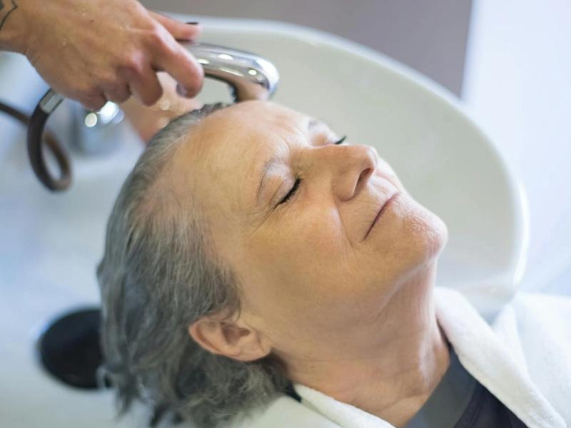 Senior receiving a hair treatment at a salon