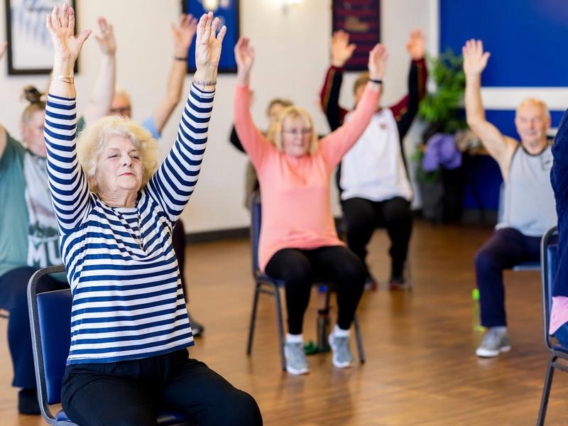 Residents participating in a seated exercise class