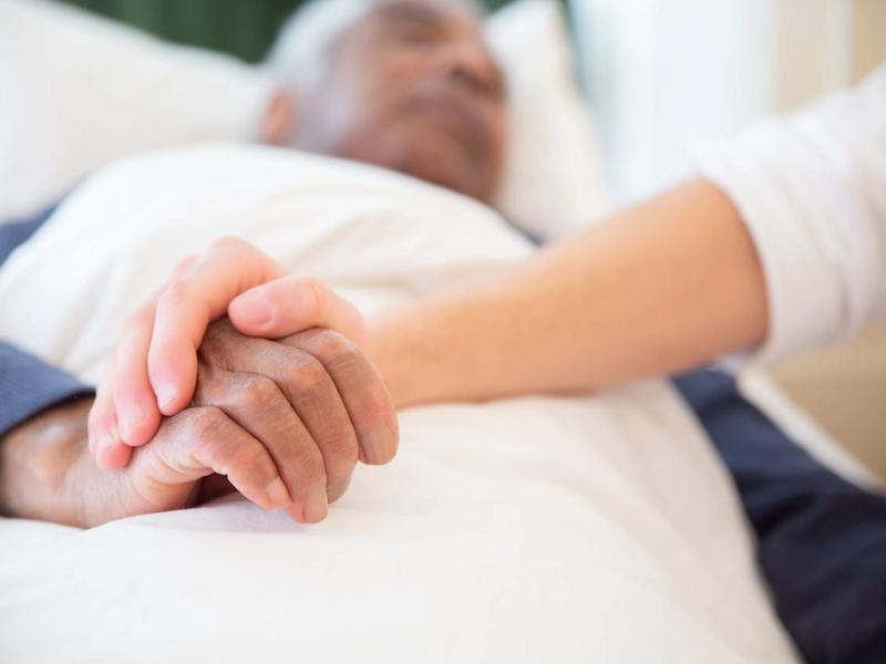 Caregiver holding the hand of a senior resident