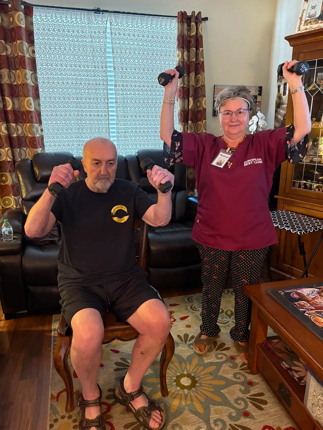 A resident and staff member engaged in exercise.