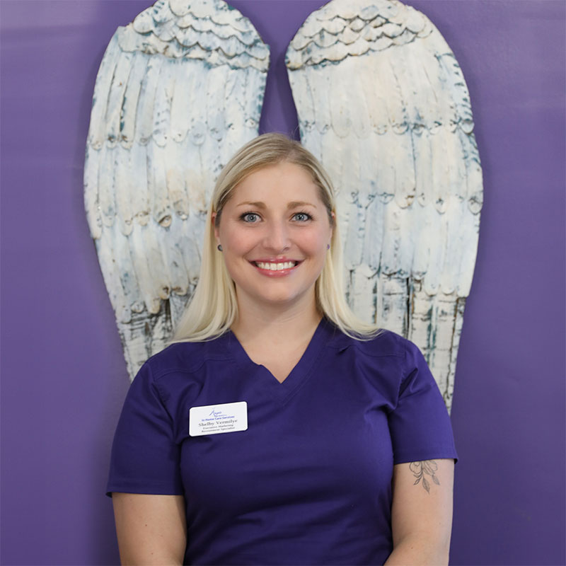 Staff member in front of decorative wings