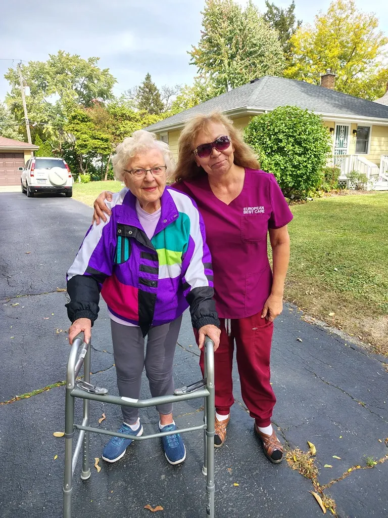 Senior resident and staff member outdoors
