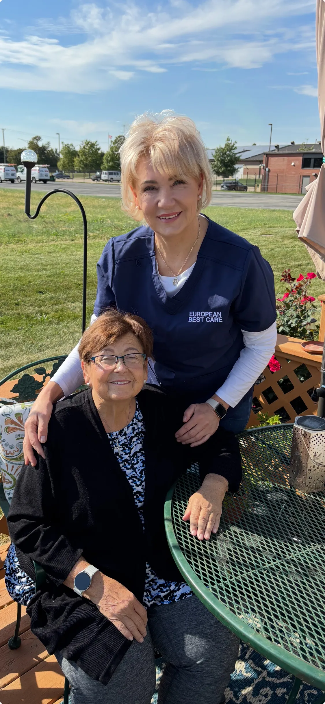Staff member with resident outdoors at a table.