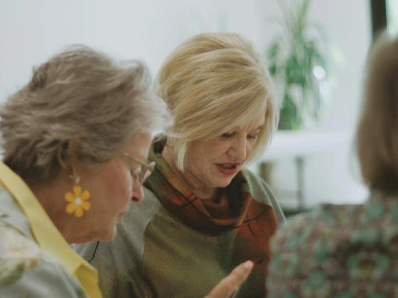 Two women engaged in conversation indoors.