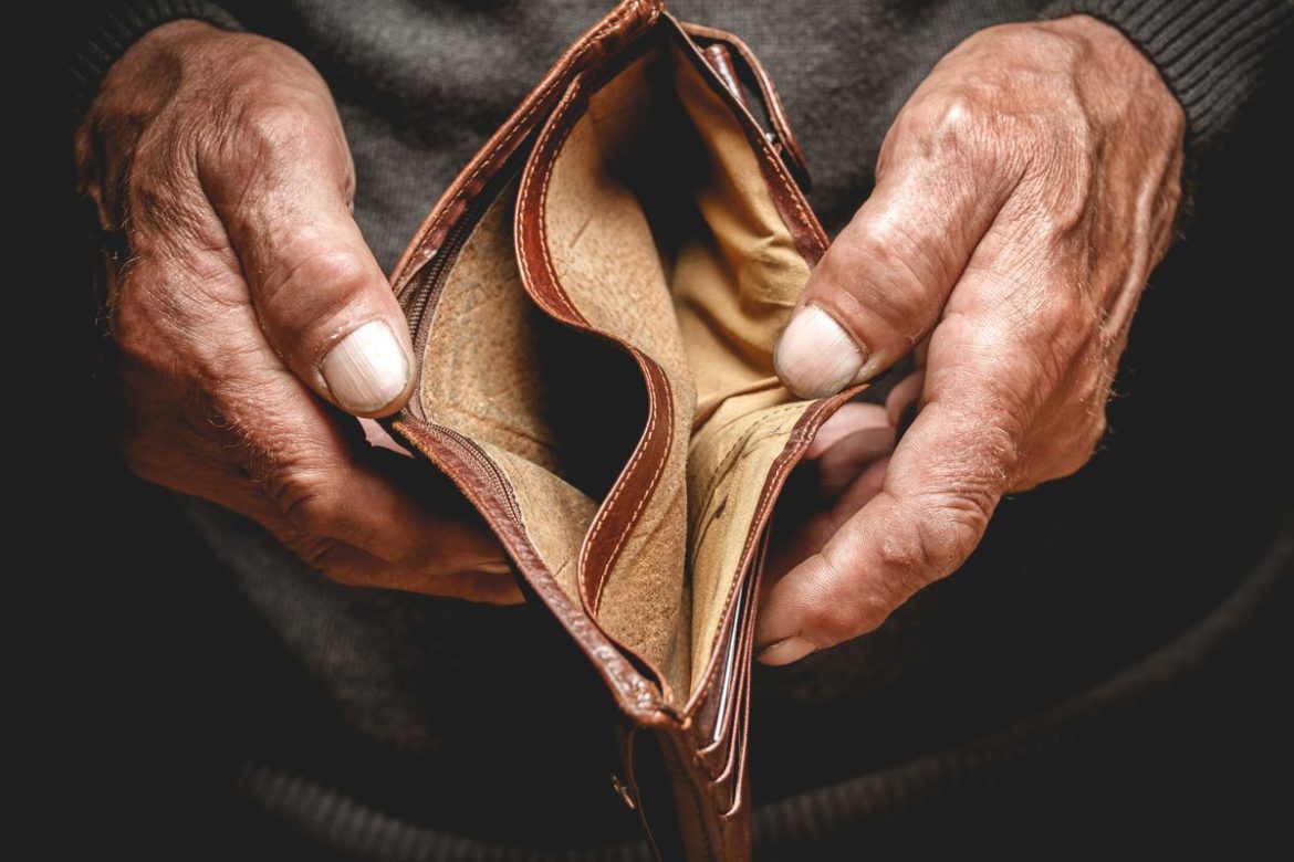 Elderly hands holding an empty wallet