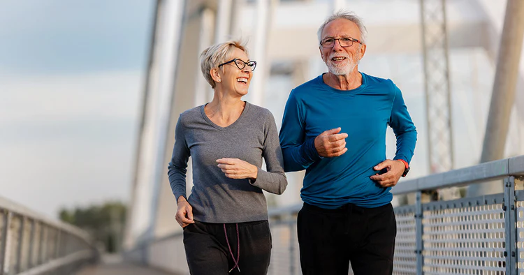 Active seniors jogging on a bridge.
