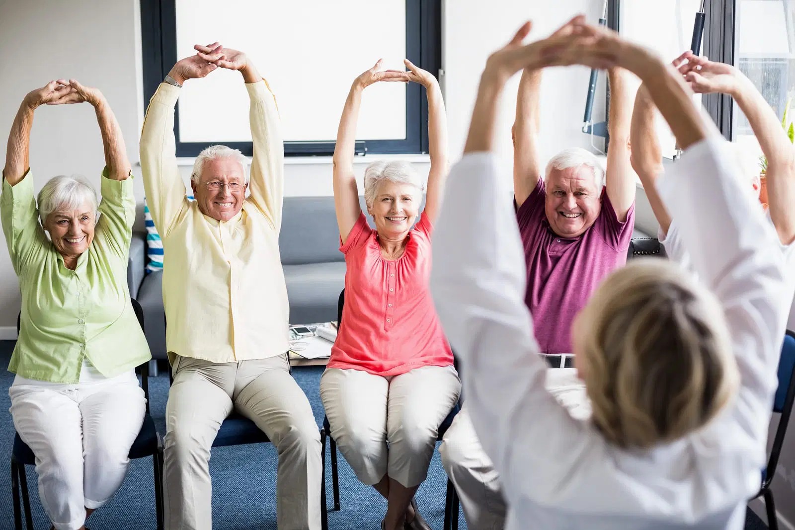 Seniors participating in a group stretching activity.