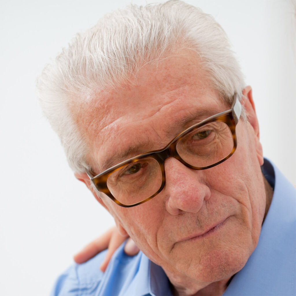 Older man with glasses showing a thoughtful expression.