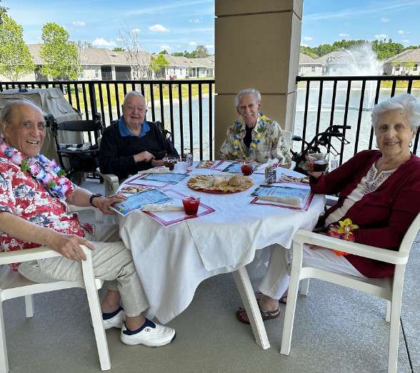 Residents enjoying a meal outdoors with drinks.