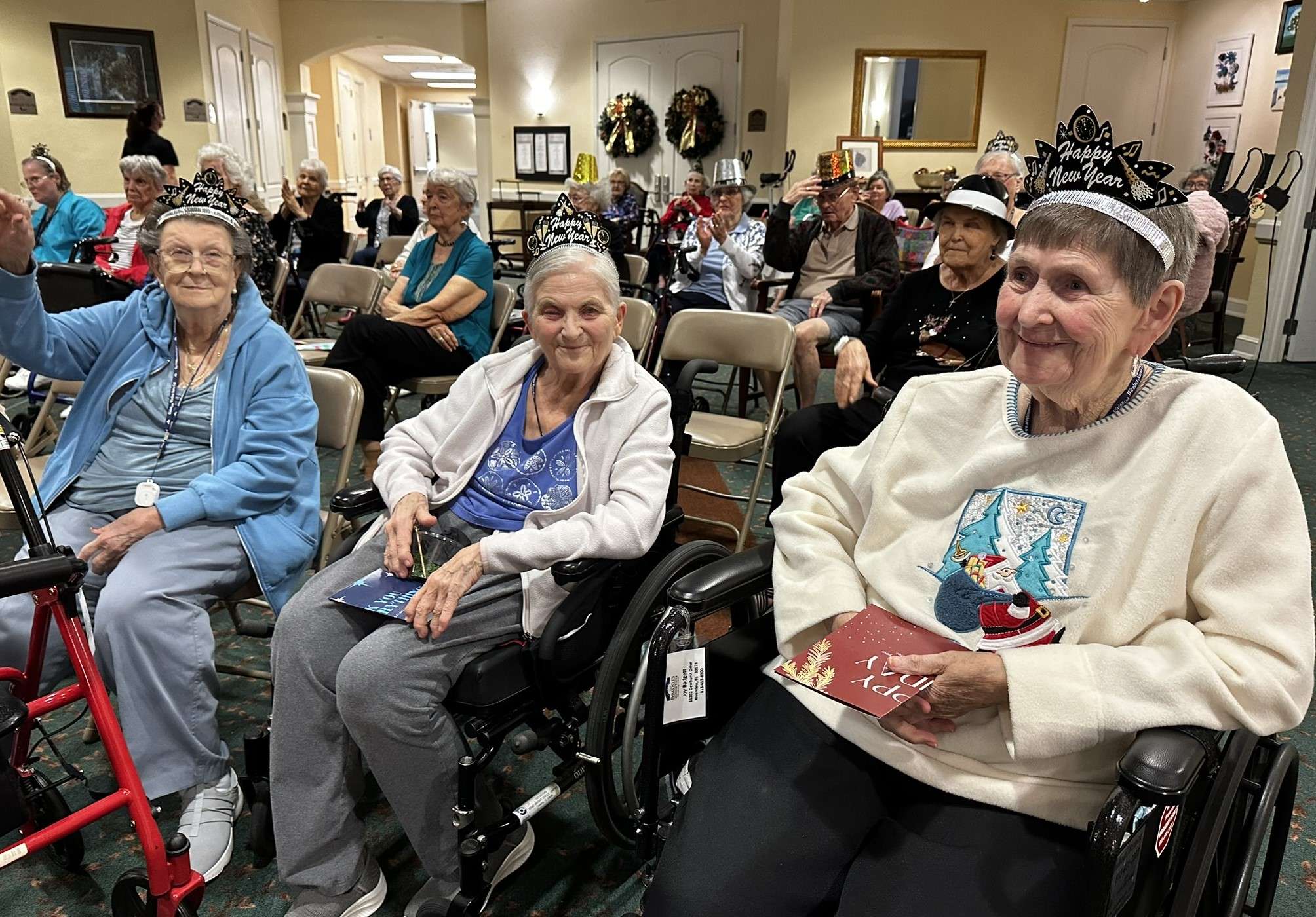 Residents celebrating in a common area with festive hats