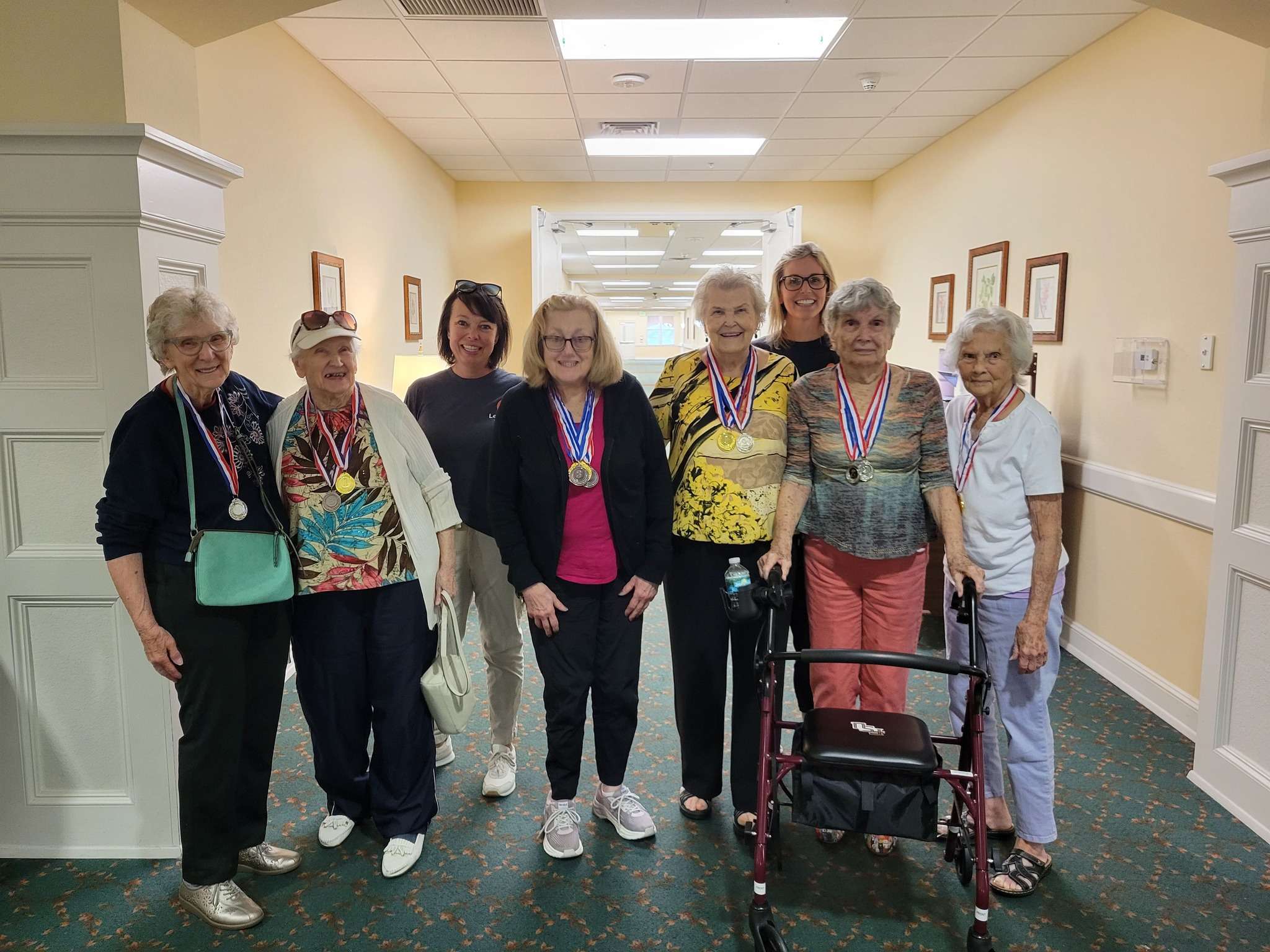 Residents celebrating with medals in a hallway