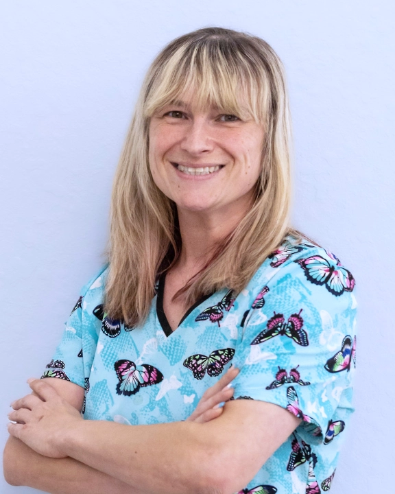 Healthcare worker smiling in colorful scrubs.