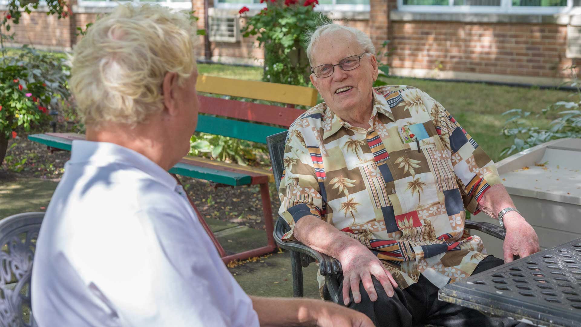 Two residents enjoying a conversation outdoors.