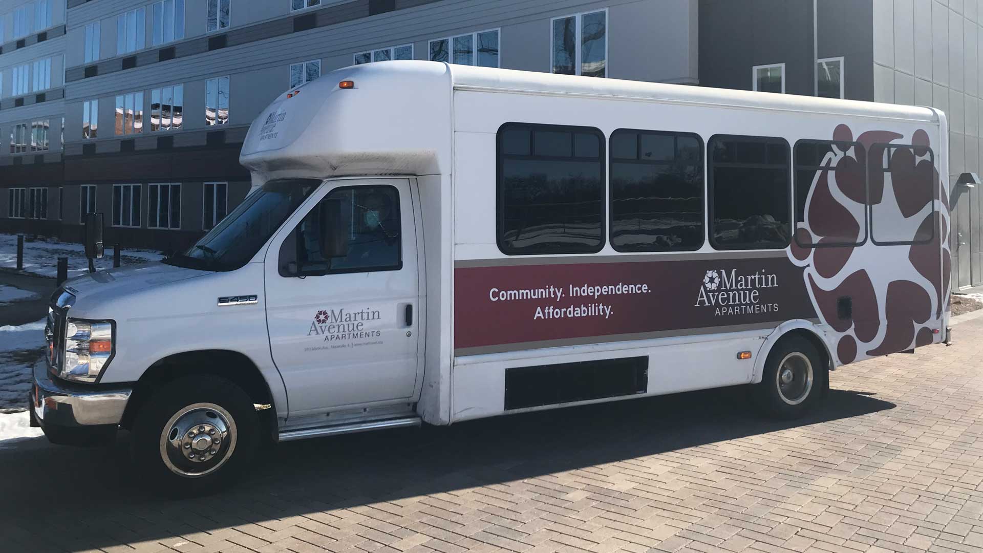 Facility transport van with branding and slogan.