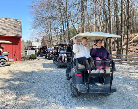 Residents enjoying a golf cart ride outdoors.