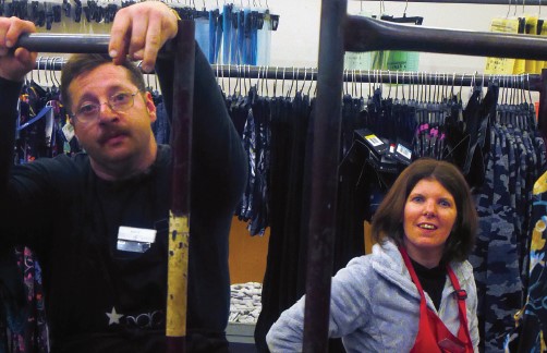 Two staff members working on a clothing rack.