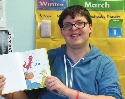 Resident participating in an activity with a book.