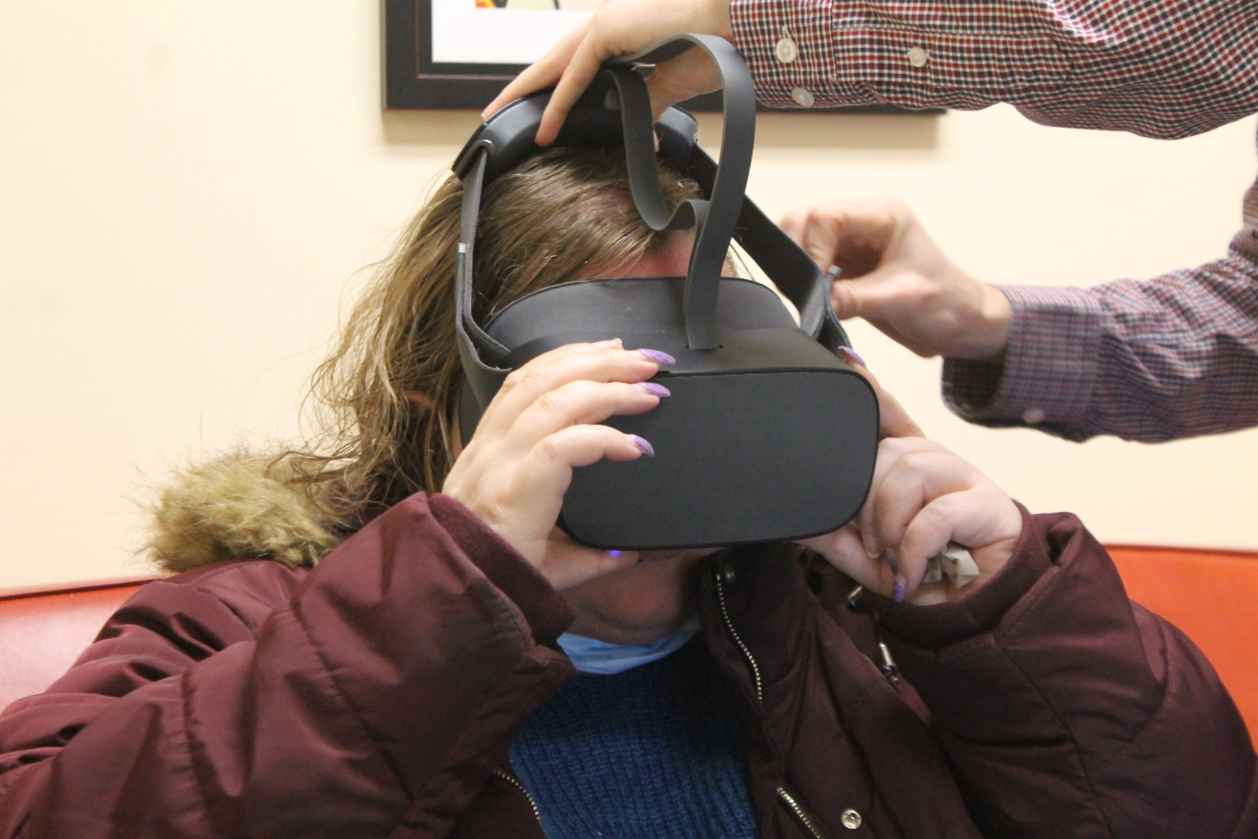 Resident using virtual reality headset with assistance.