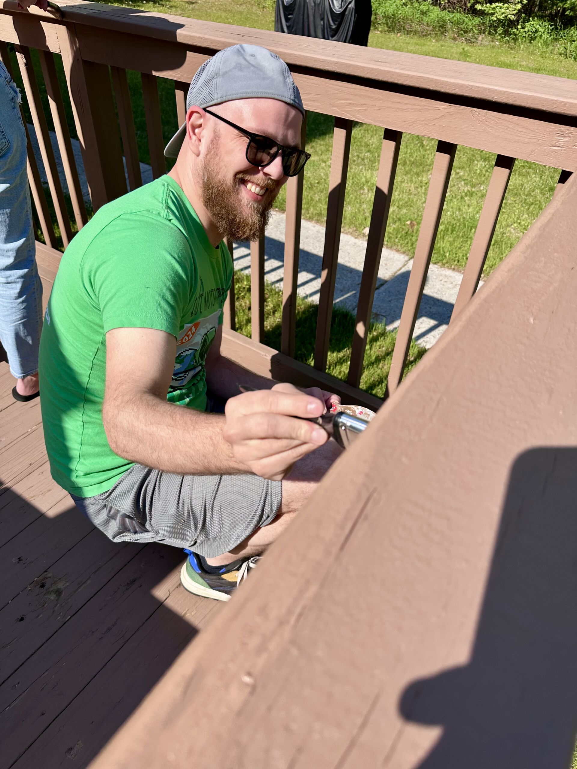 Person painting a railing outdoors at the facility.