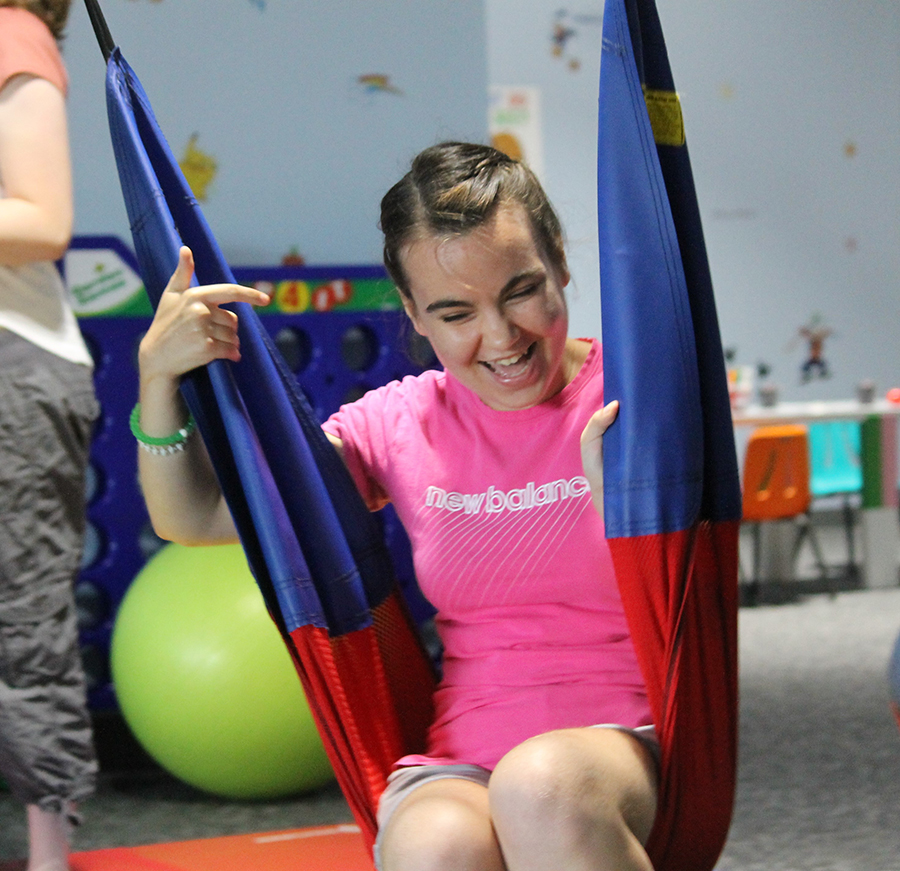 Young woman enjoying a swing in an indoor play area.