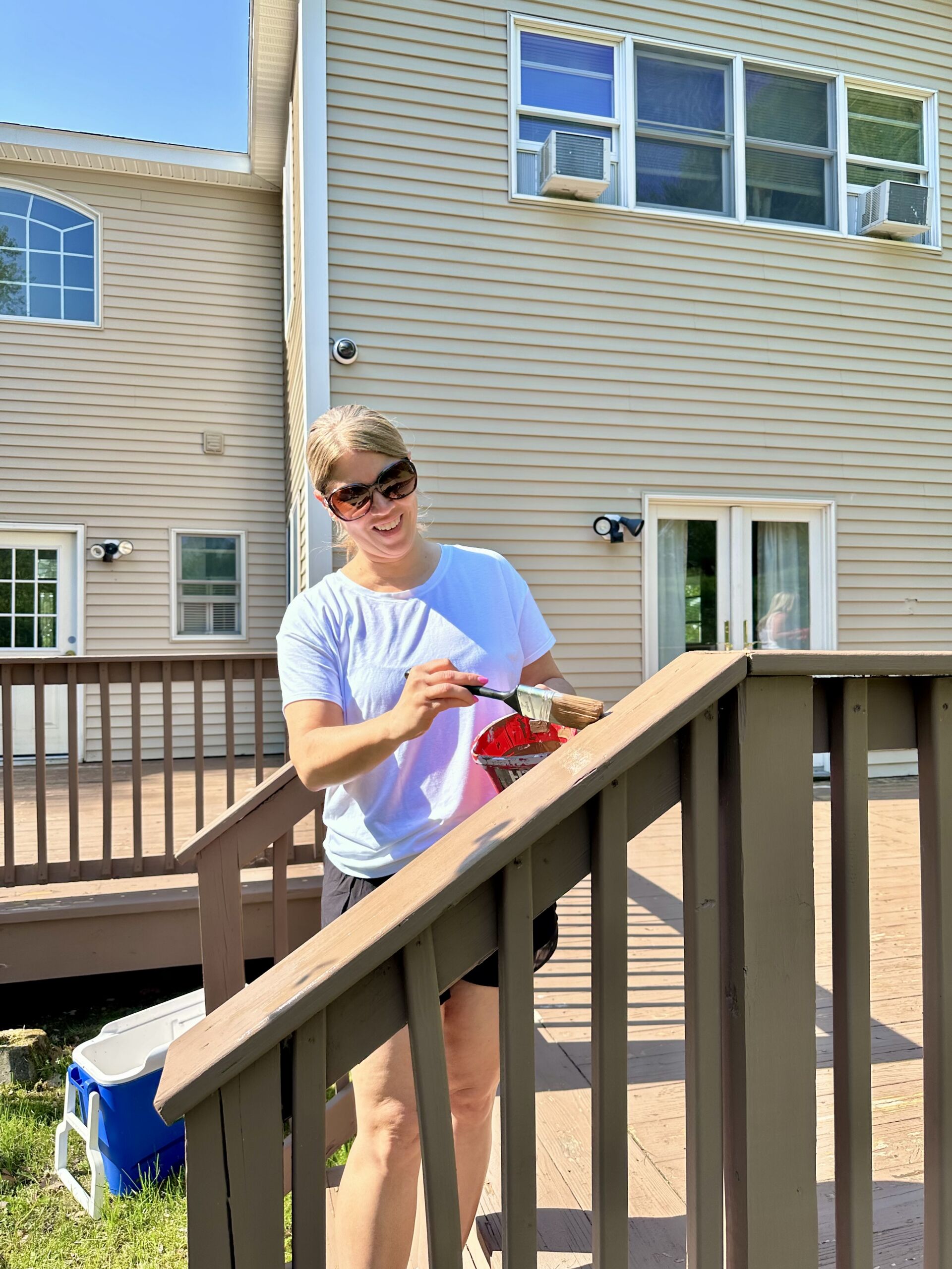 A staff member painting railings outdoors.