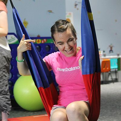Young woman enjoying a swing in a playful setting.