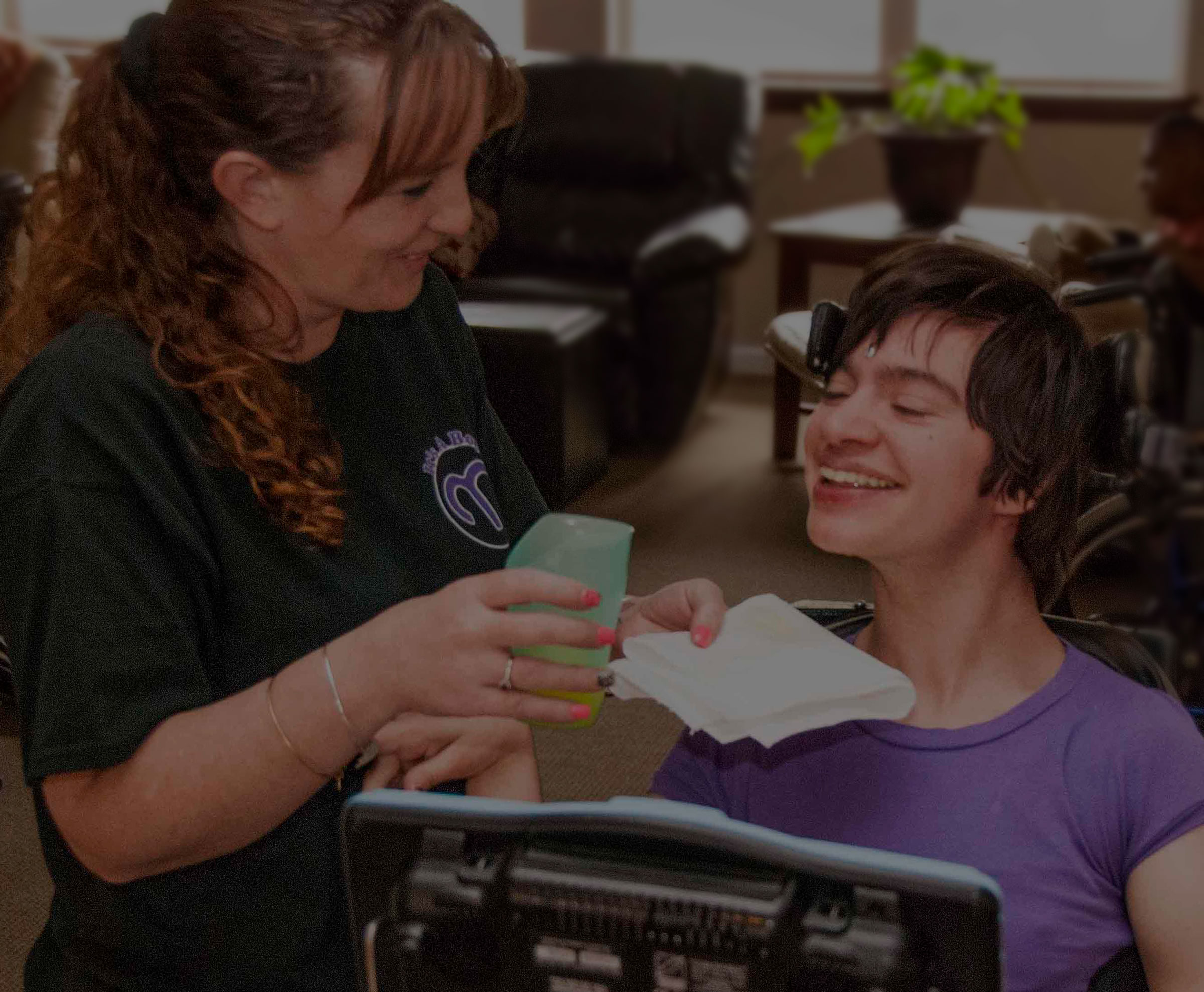 Caregiver assisting a resident in a common area.