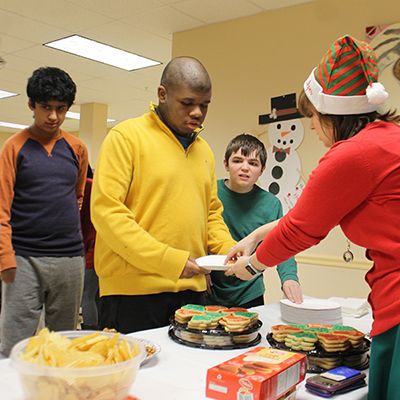 Residents and staff participating in a holiday cookie activity.