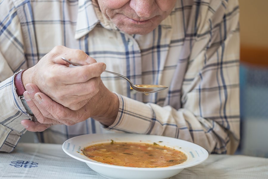 Senior man enjoying a bowl of soup.