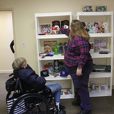 Residents engaging with shelves of toys and items.