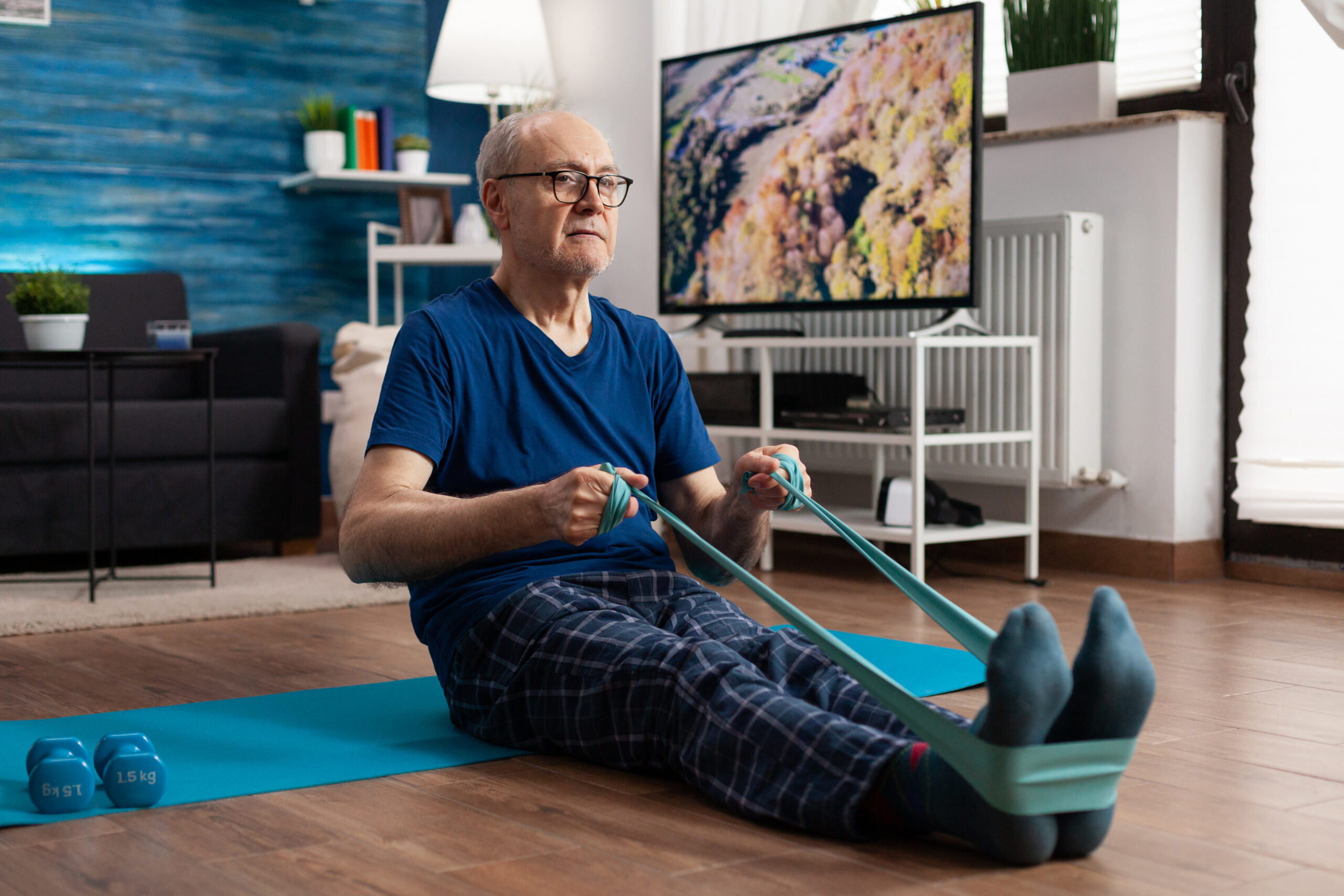 Senior man exercising indoors with resistance bands
