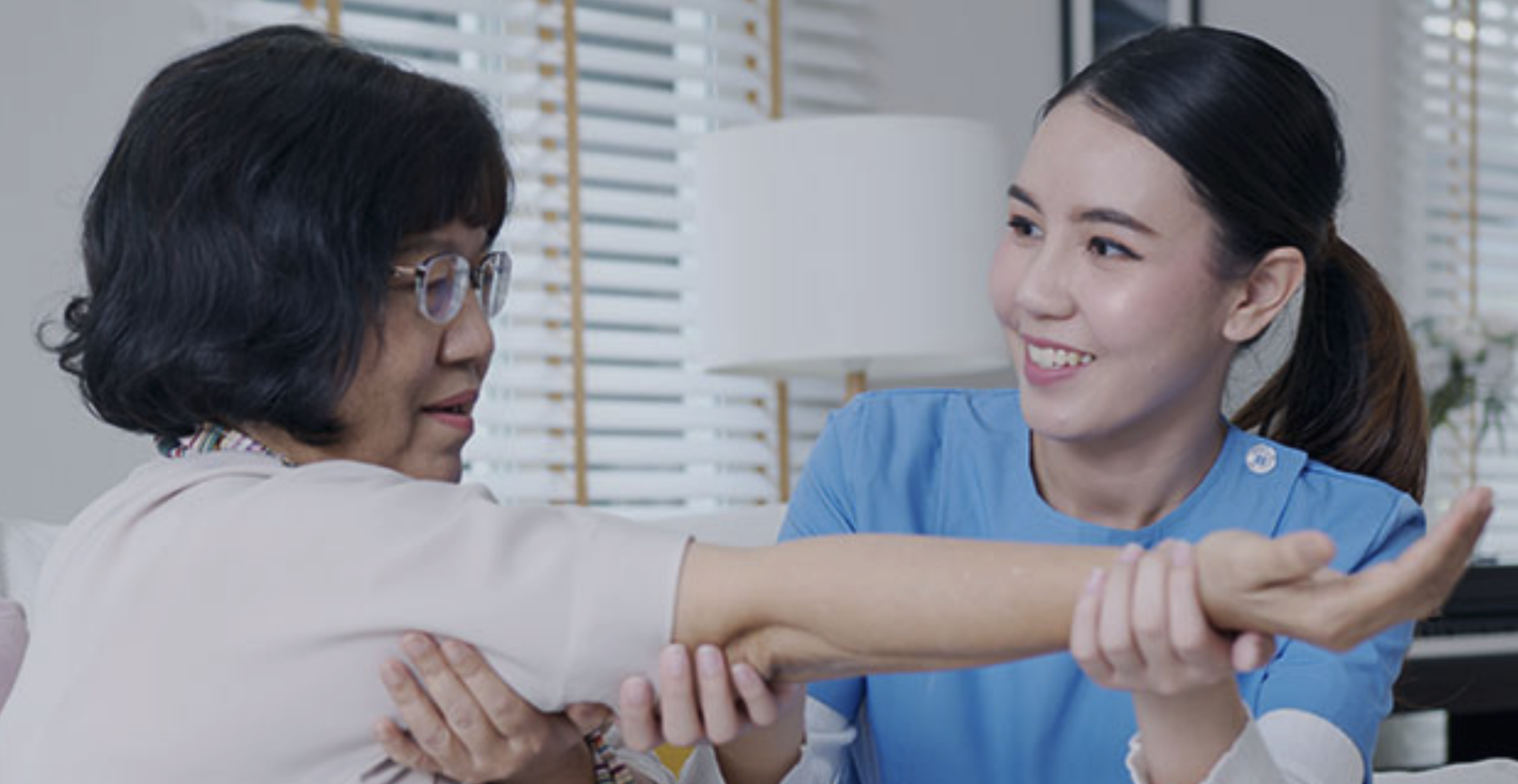 Caregiver assisting a resident in a warm setting.