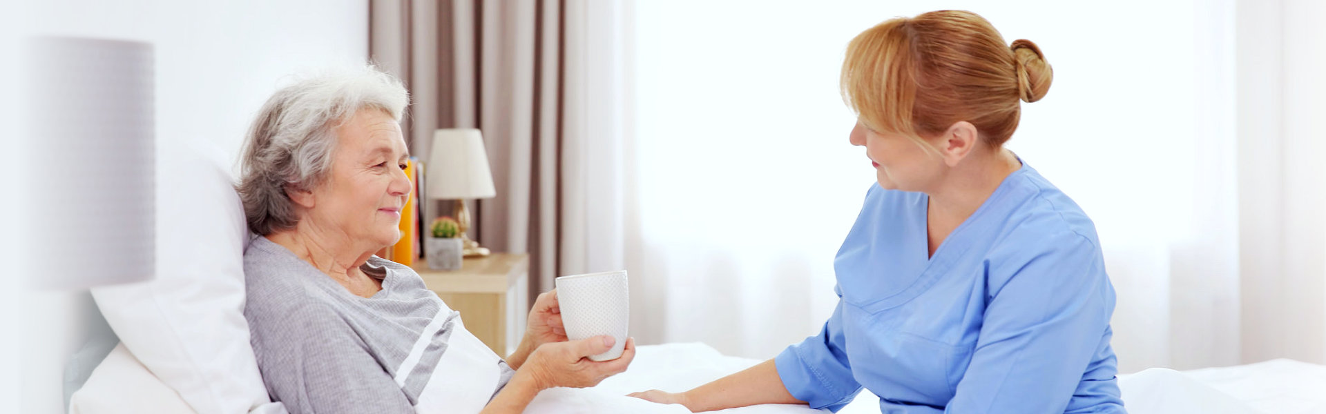 Caregiver talking to a senior resident in bed