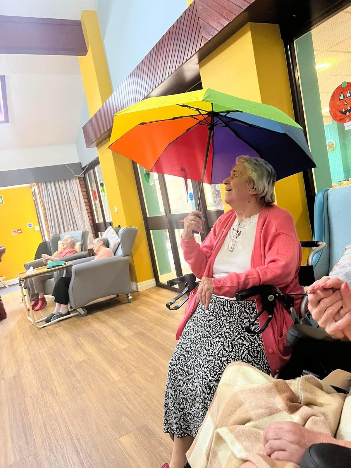 Resident enjoying a colorful umbrella in the common area.